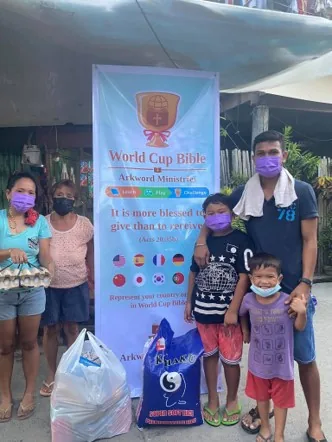 A family receiving food and supplies from the ArkWord team